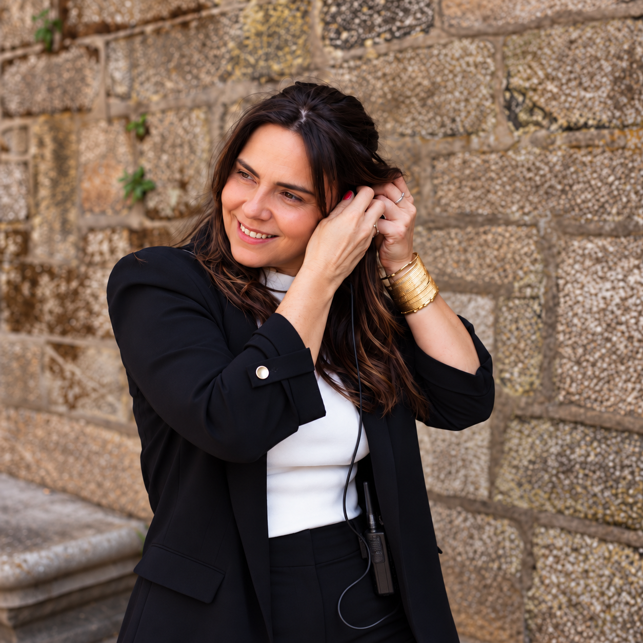 Ana García, wedding planner de MINIMÚ ATELIER, colocándose el auricular de coordinación durante una boda en Galicia.