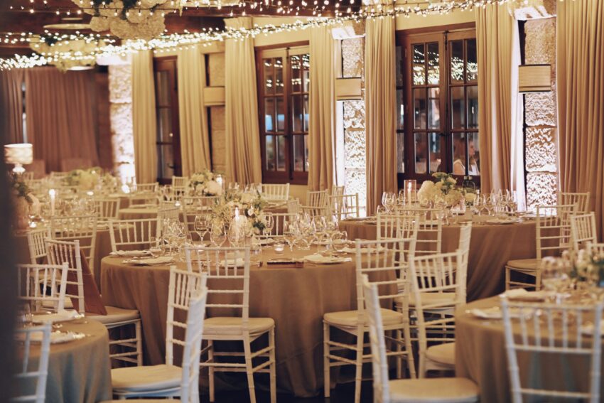 Alejandra & Rubén | Decoración del banquete en Bodegas Lagar de Pintos Galicia Vista general del salón de boda de Alejandra y Rubén, con mesas elegantes, arreglos florales blancos e iluminación cálida.