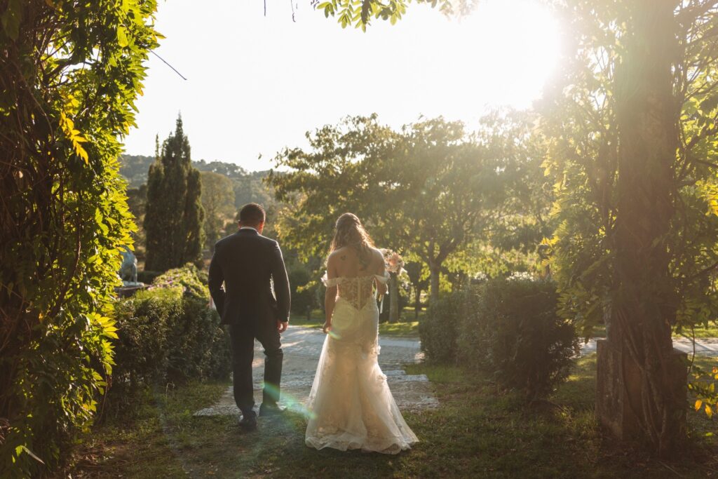 Pareja de novios caminando por un jardín en Galicia al atardecer