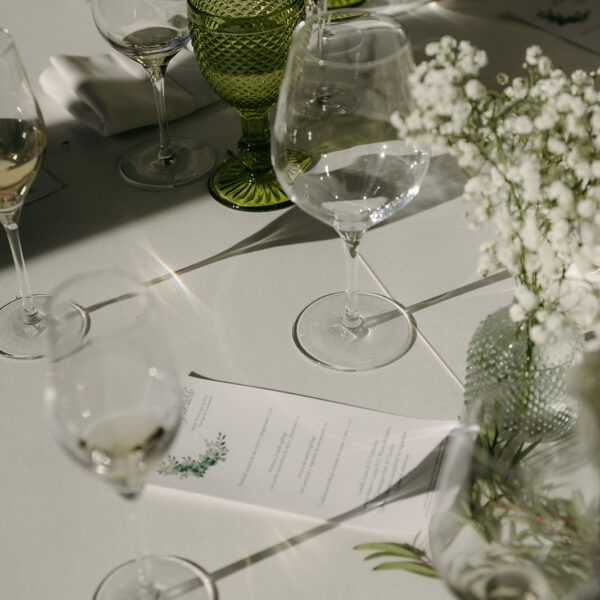 Detalle de mesa de Laura & Pablo | Pazo San Lorenzo Detalle de mesa con copa verde y papelería en la boda de Laura y Pablo