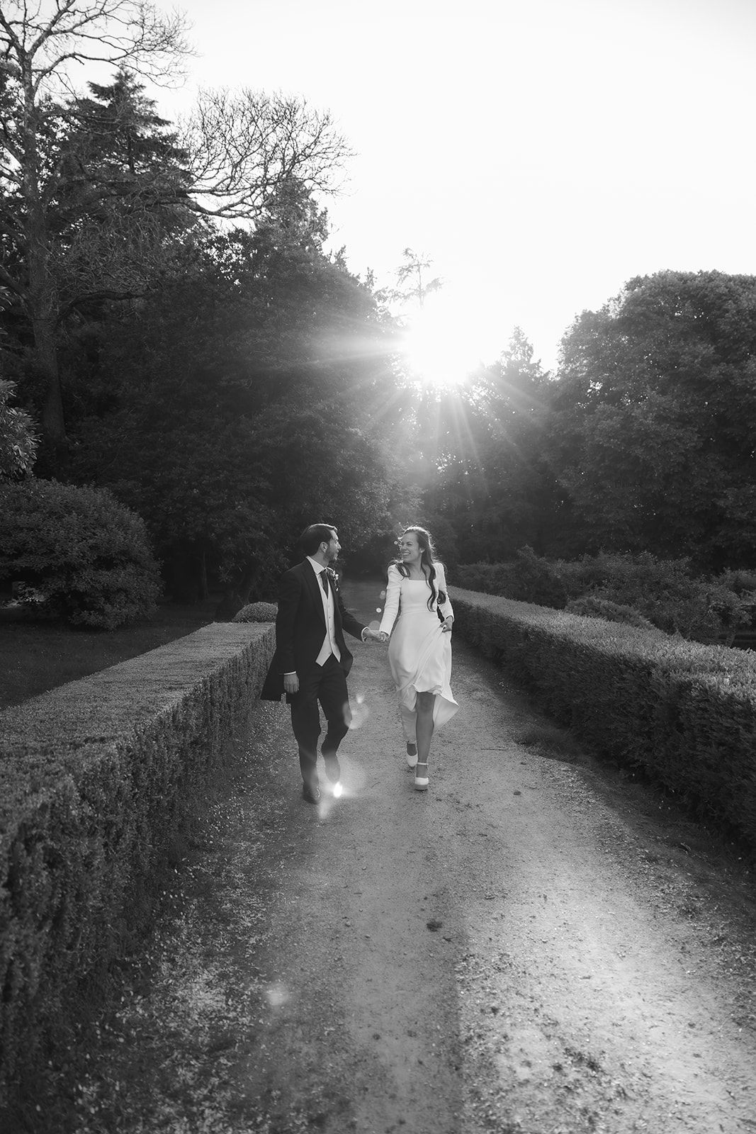 Laura y Pablo paseando de la mano por los jardines del Pazo San Lorenzo en Santiago de Compostela durante su boda.
